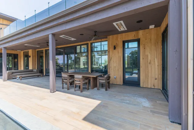 a view of living room filled with furniture and large windows
