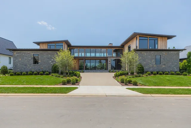 a front view of a house with a yard and a garage