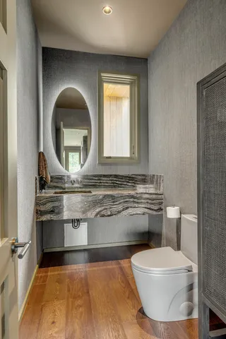 a bathroom with a granite countertop sink a toilet and a mirror