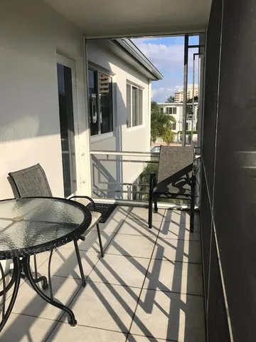 a balcony view with a table and chairs