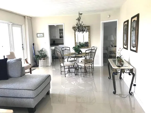 a living room with furniture a dining table and a large mirror