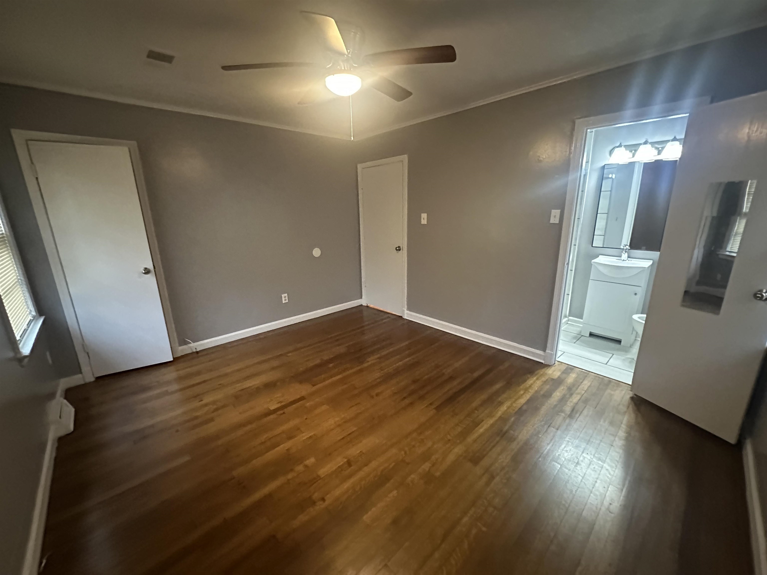 1285 Old Hickory Road Memphis, TN 38116 - Photo 12 of 31 Unfurnished bedroom with connected bathroom, baseboards, dark wood finished floors, and crown molding