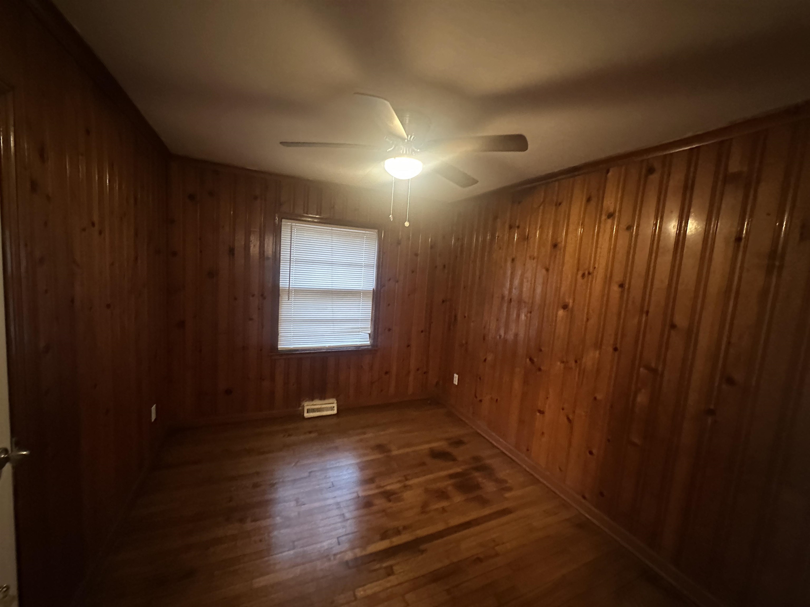 1285 Old Hickory Road Memphis, TN 38116 - Photo 14 of 31 Spare room featuring wood walls, ceiling fan, and dark wood finished floors