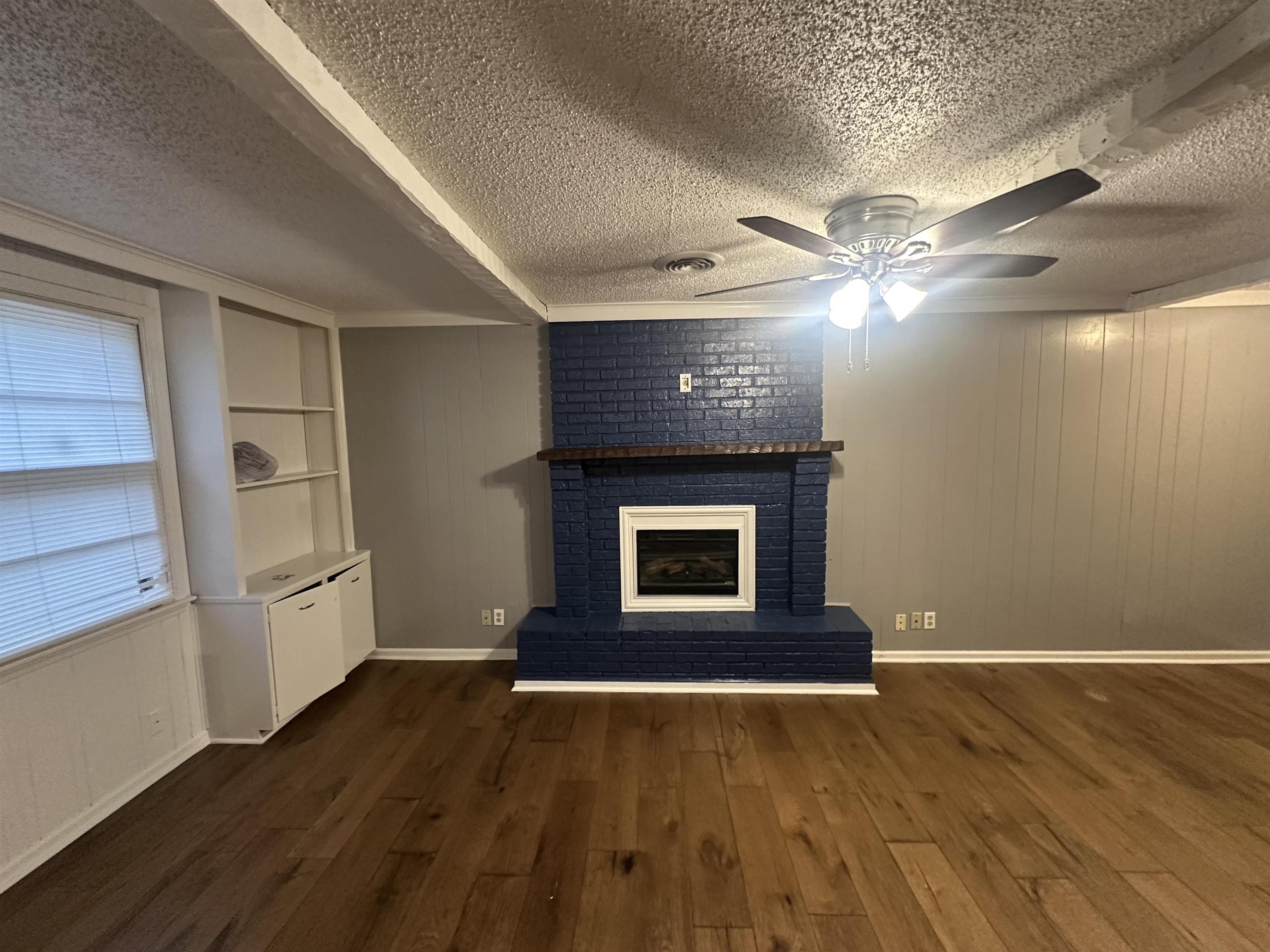 1285 Old Hickory Road Memphis, TN 38116 - Photo 24 of 31 Unfurnished living room featuring a fireplace, dark wood finished floors, visible vents, a ceiling fan, and a textured ceiling