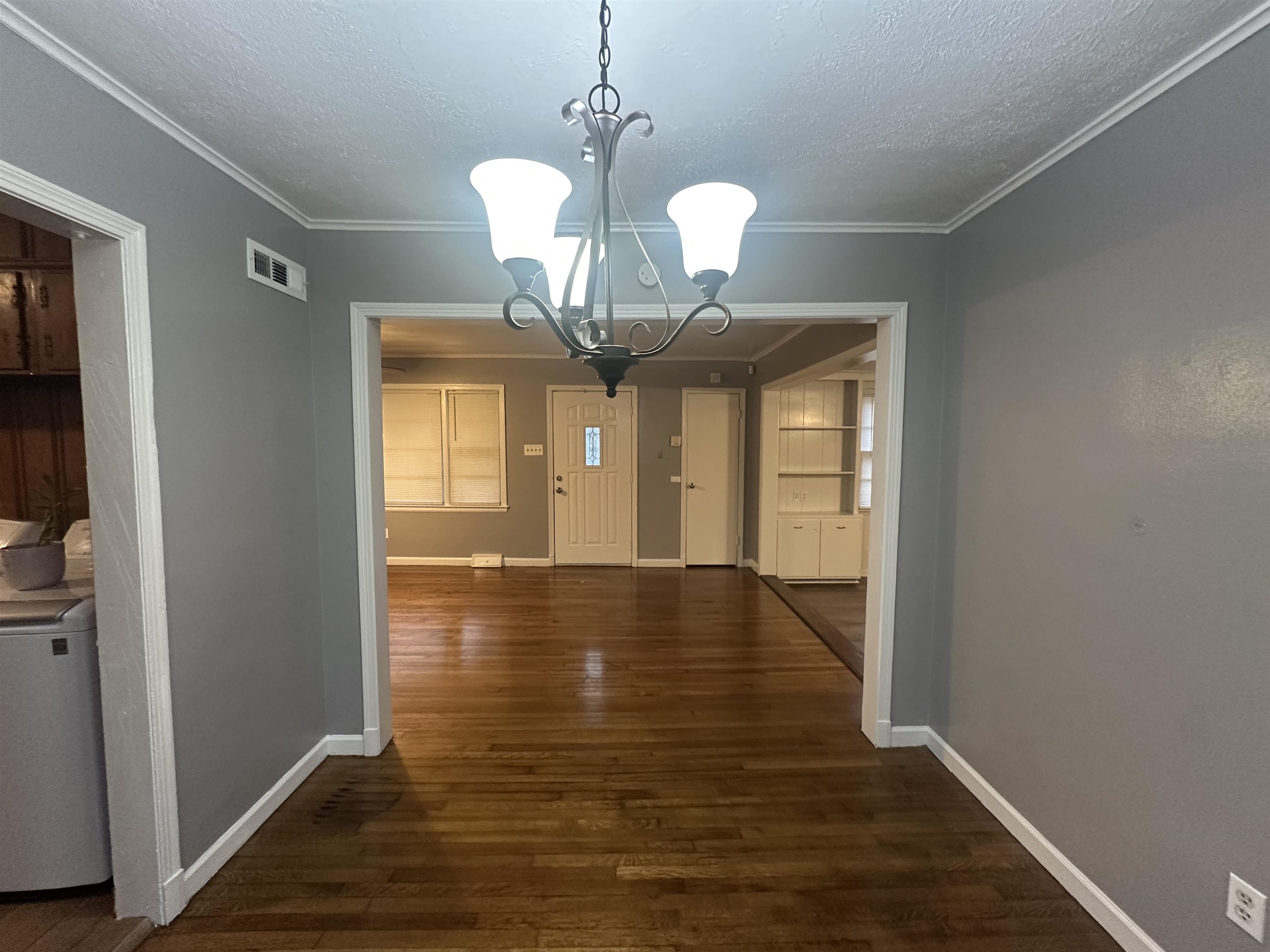 1285 Old Hickory Road Memphis, TN 38116 - Photo 4 of 31 Unfurnished dining area with visible vents, a chandelier, dark wood-type flooring, and ornamental molding