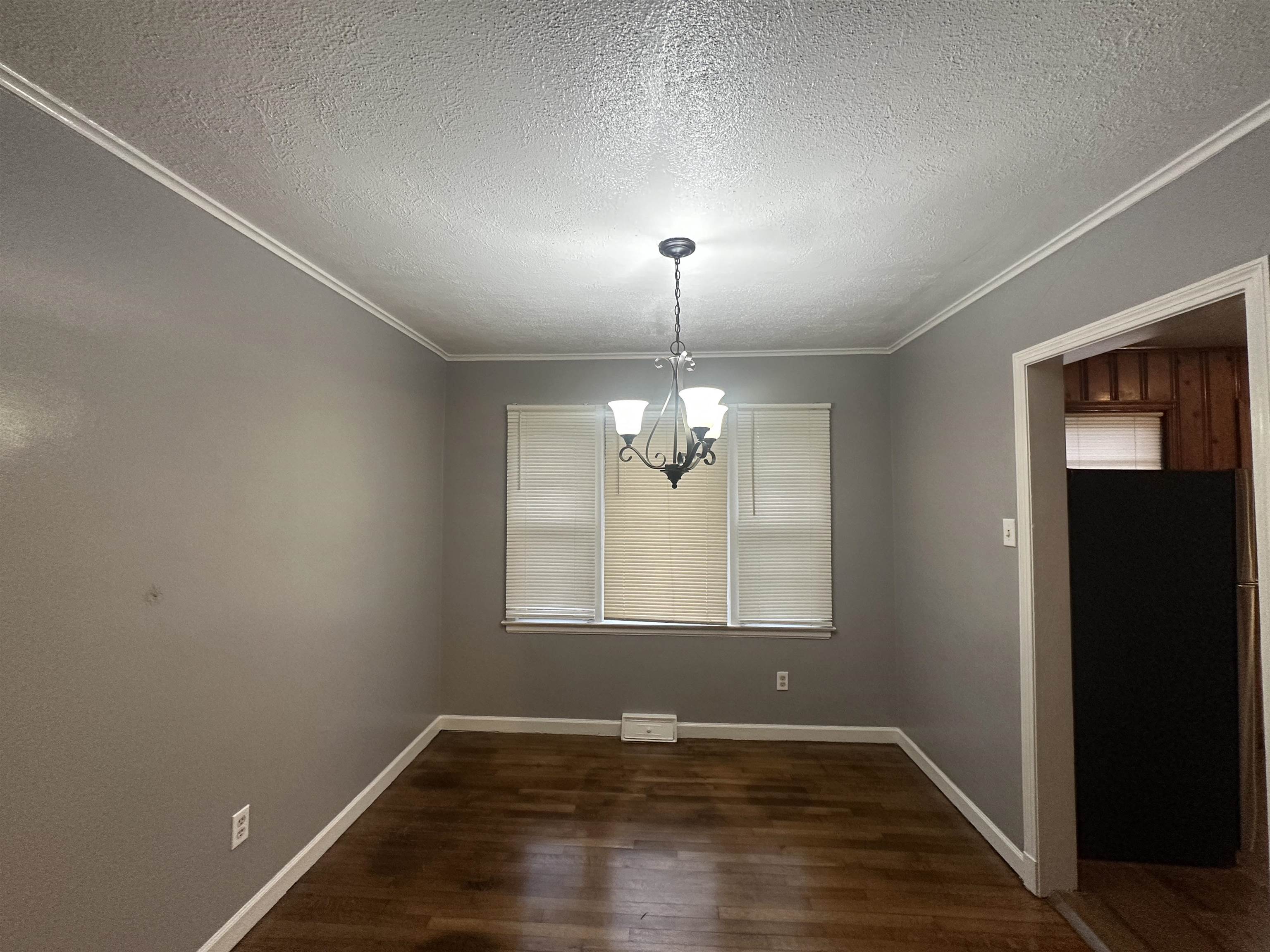 1285 Old Hickory Road Memphis, TN 38116 - Photo 5 of 31 Unfurnished dining area with a notable chandelier, crown molding, baseboards, and dark wood-style flooring