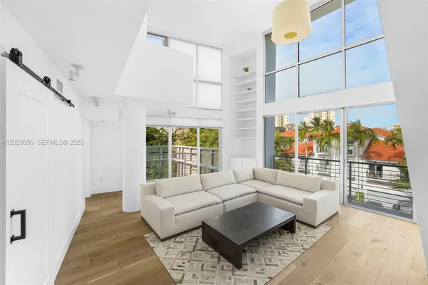 a living room with furniture and a floor to ceiling window