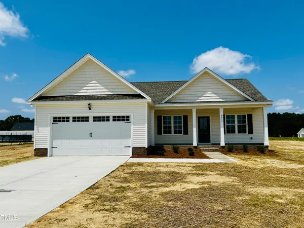 a front view of a house with a yard outdoor seating and garage