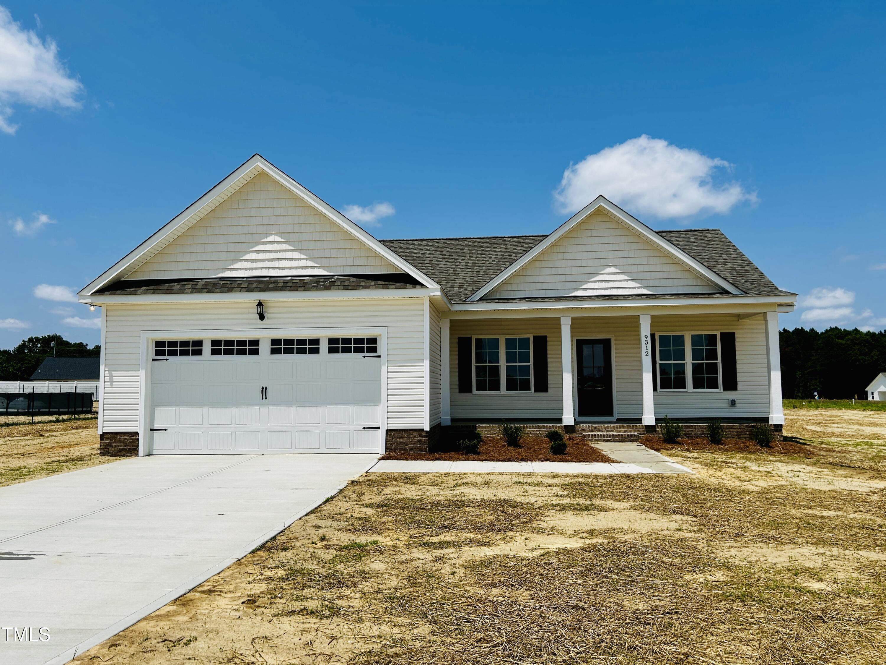 a front view of a house with a yard outdoor seating and garage