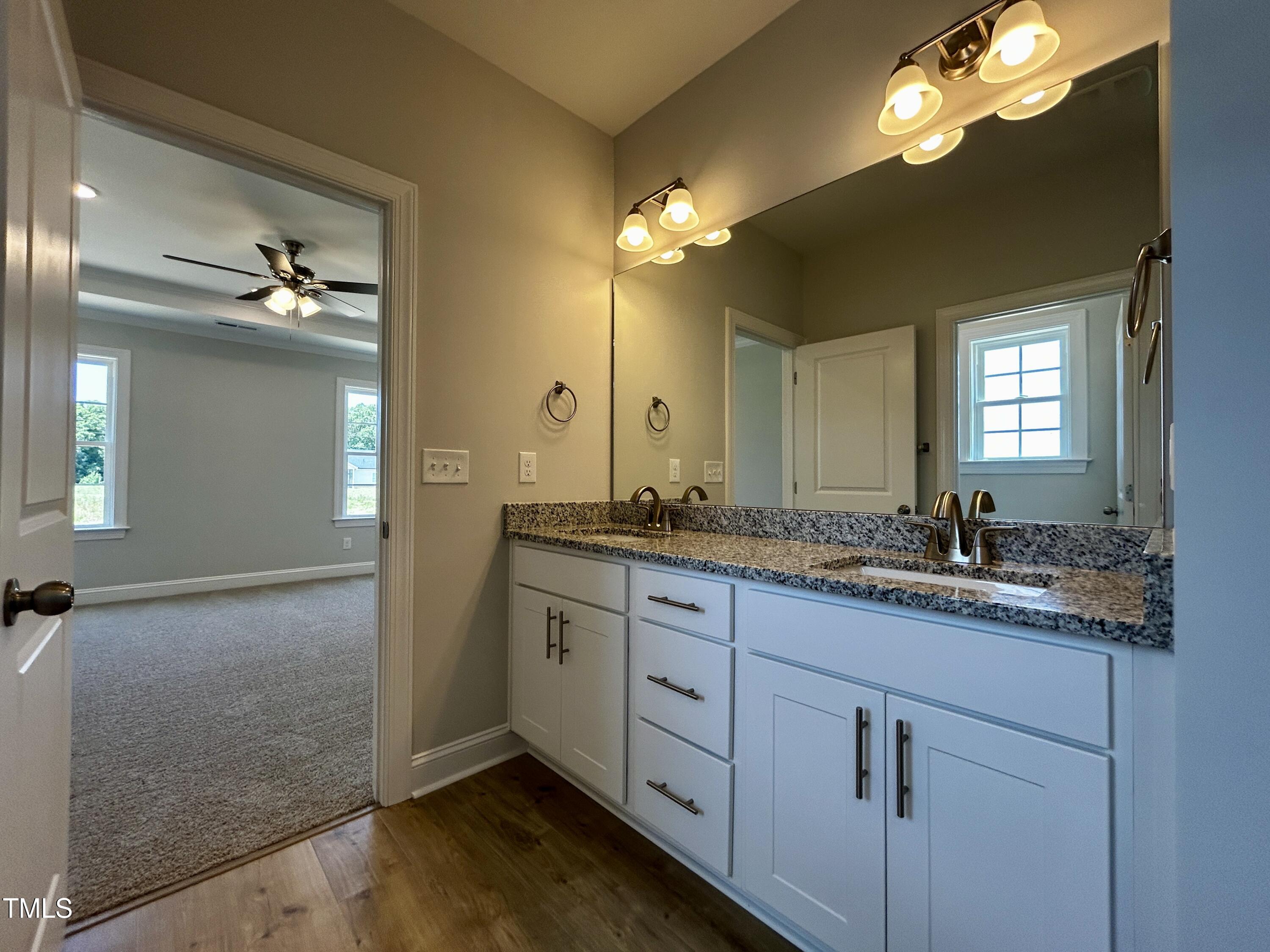3912 Origin Drive Bailey, NC 27807 - Photo 11 of 20 a bathroom with a granite countertop sink a large mirror and a shower