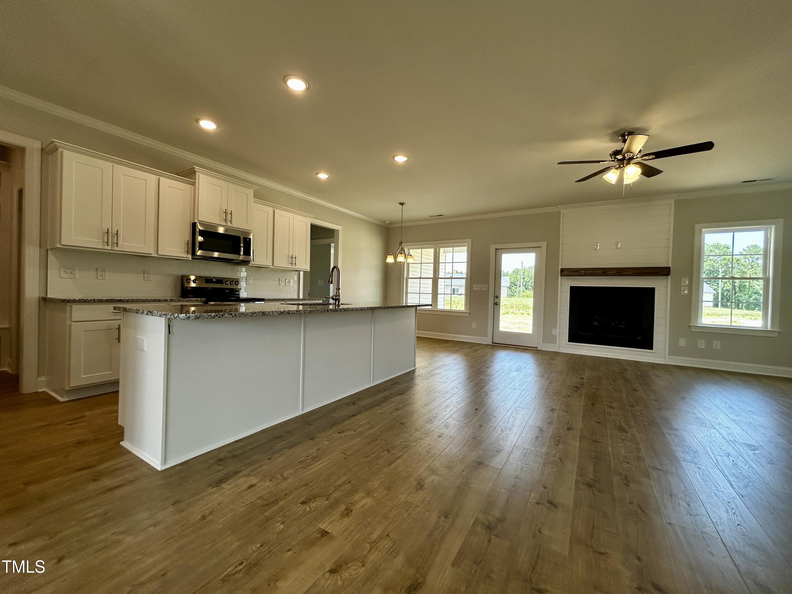 3912 Origin Drive Bailey, NC 27807 - Photo 5 of 20 a view of open kitchen with kitchen island wooden floors appliances and cabinets