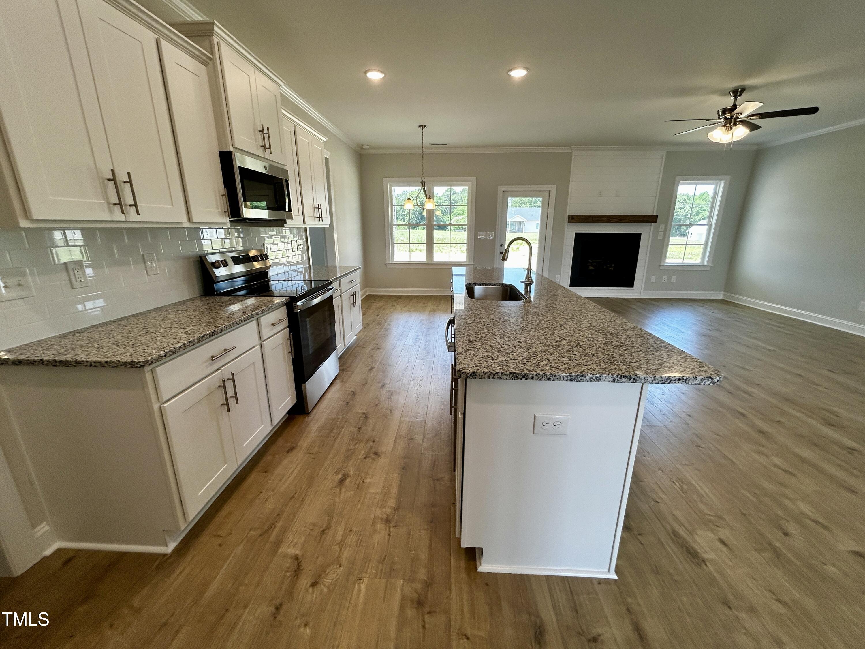 3912 Origin Drive Bailey, NC 27807 - Photo 8 of 20 a large kitchen with granite countertop a sink a counter top space appliances and cabinets