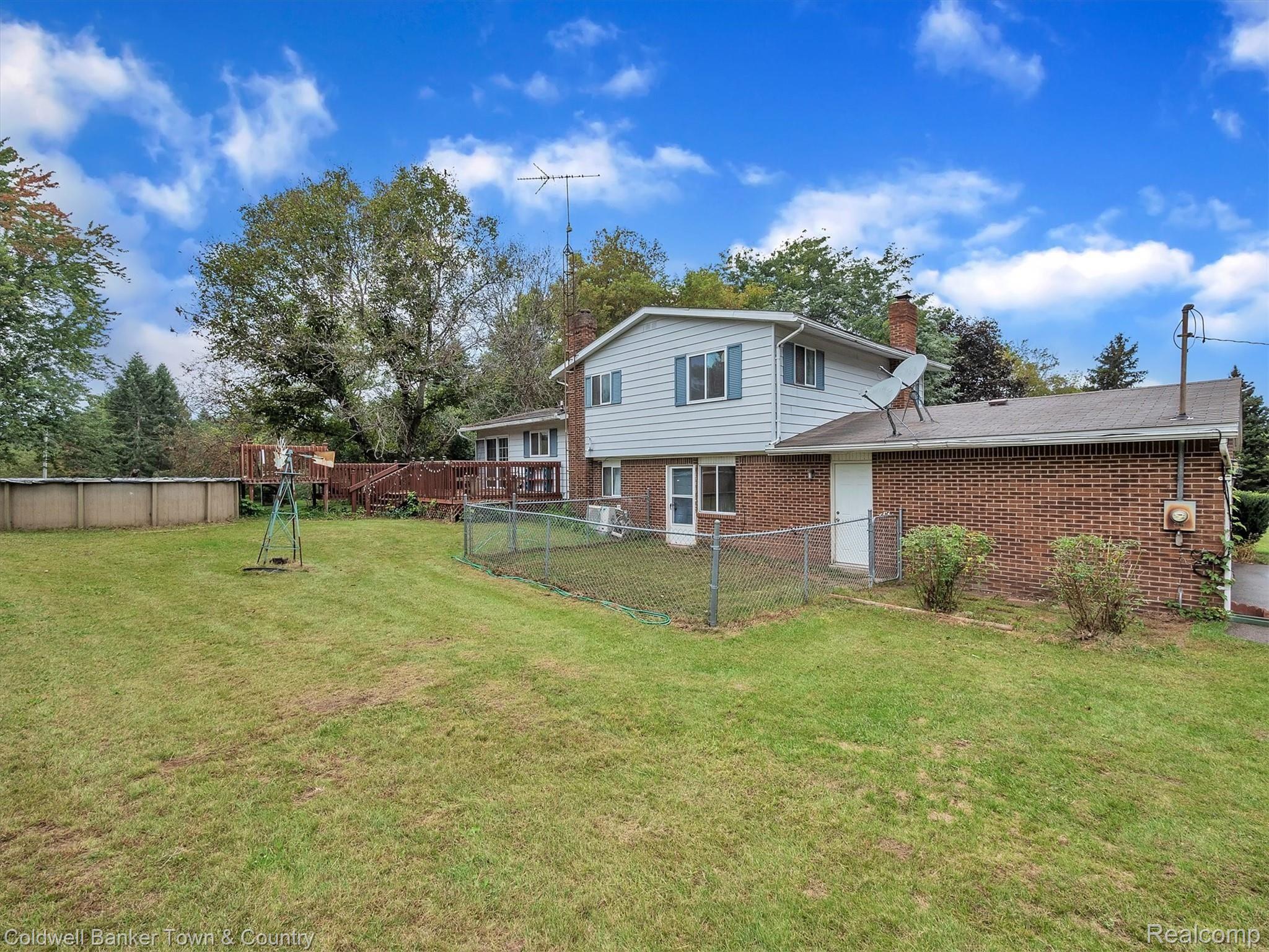 5432 Evans Road Holly, MI 48442 - Photo 36 of 39 Backyard with large deck, above ground pool, and fenced in area
