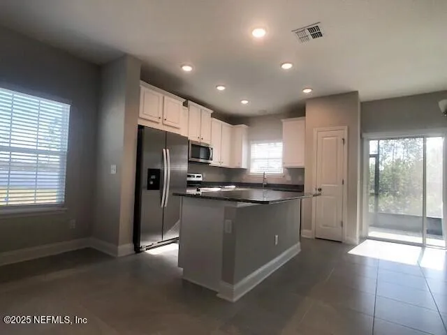 a kitchen with stainless steel appliances granite countertop a refrigerator and a stove