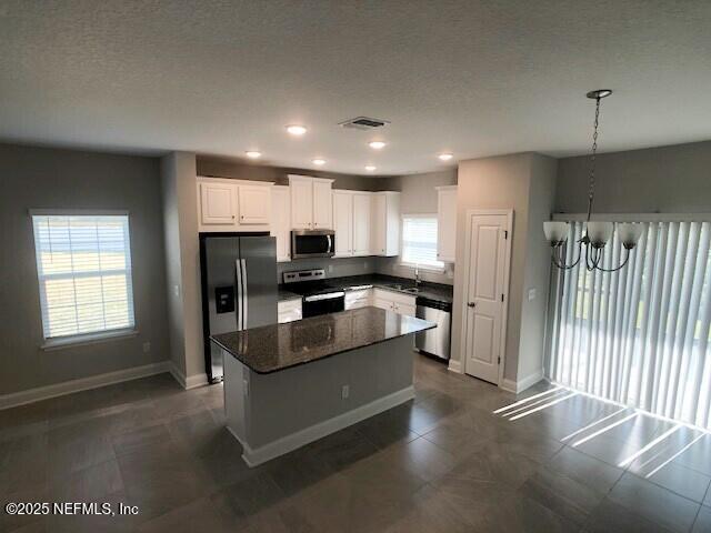 13991 Molina Drive Jacksonville, FL 32256 - Photo 6 of 34 a kitchen with stainless steel appliances kitchen island granite countertop a refrigerator oven a sink dishwasher and white cabinets with wooden floor