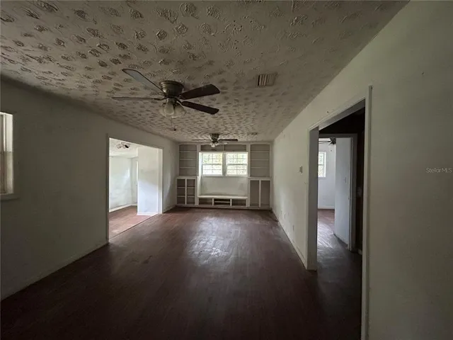 a view of a livingroom with a ceiling fan and window