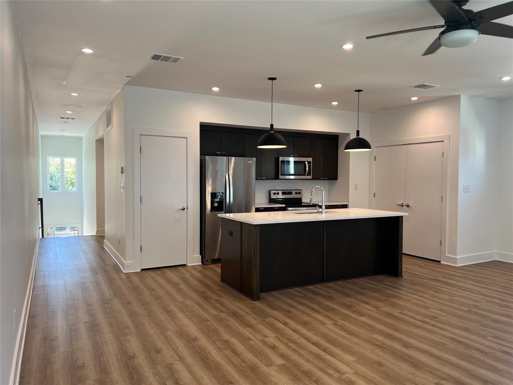 408 Martin Luther King Junior Boulevard, Unit 401 Waxahachie, TX 75165 - Photo 1 of 15 a large kitchen with stainless steel appliances kitchen island a large counter top and wooden floors