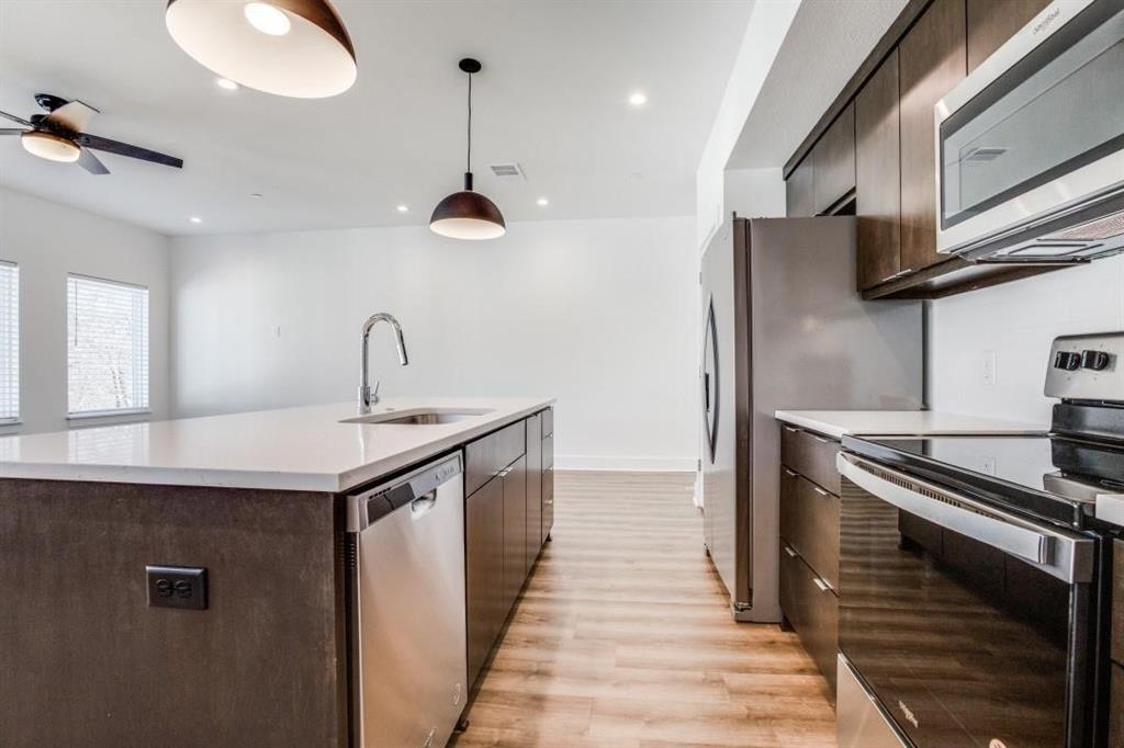 408 Martin Luther King Junior Boulevard, Unit 401 Waxahachie, TX 75165 - Photo 10 of 15 a kitchen with stainless steel appliances granite countertop a sink and a refrigerator