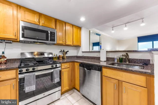 a kitchen with stainless steel appliances granite countertop a stove microwave and sink
