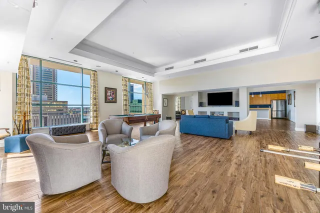 a living room with furniture kitchen view and a flat screen tv