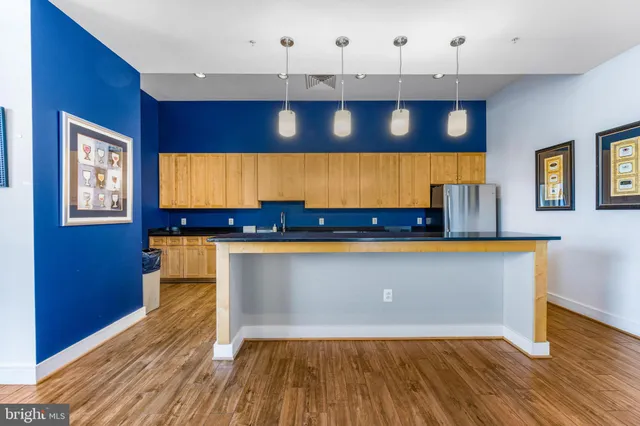 a living room with stainless steel appliances granite countertop a sink a window and wooden floor