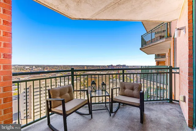 a balcony with a bench and city view