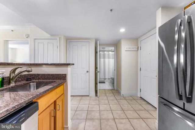 a kitchen with a sink a refrigerator and cabinets