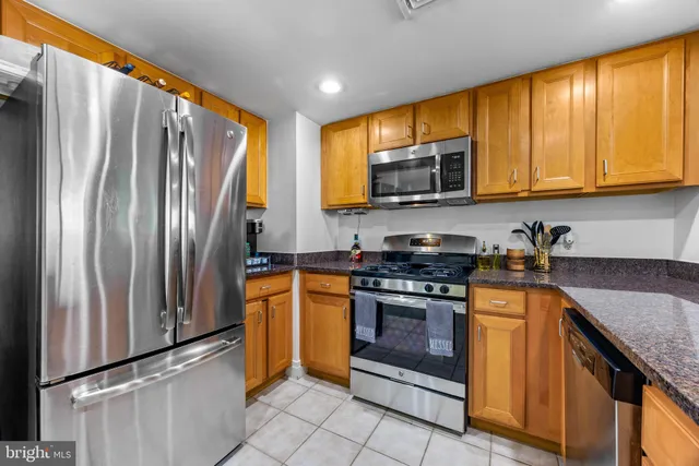 a kitchen with stainless steel appliances granite countertop a stove top oven a sink and dishwasher