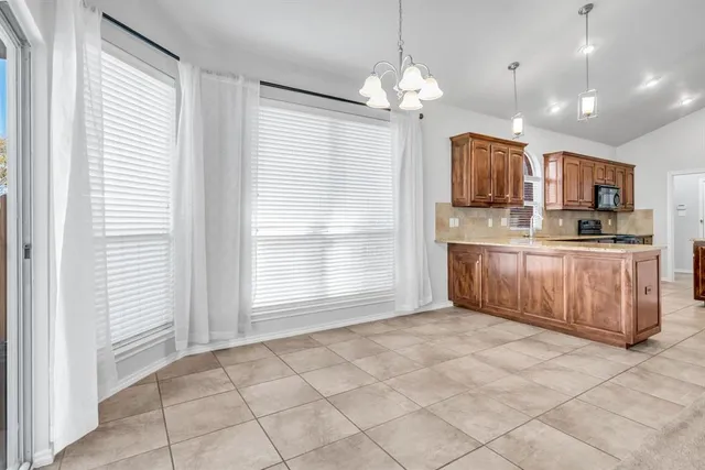a large kitchen with kitchen island a large counter space a sink and appliances