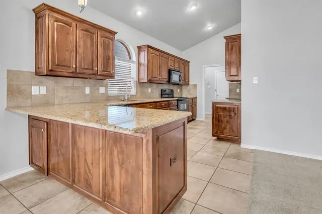 a kitchen with stainless steel appliances granite countertop a sink and cabinets