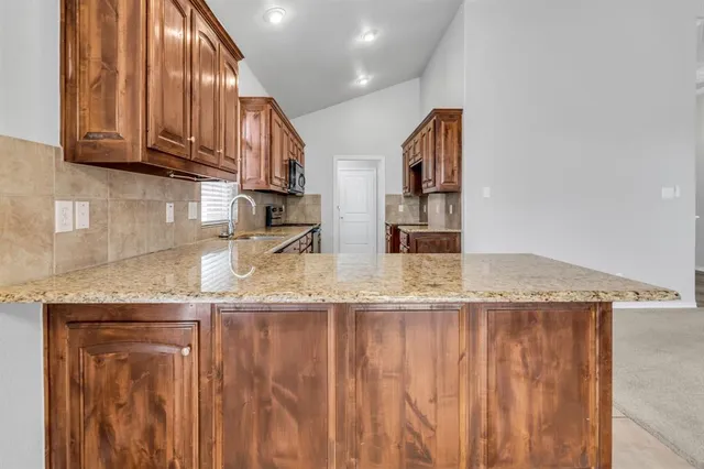 a kitchen with stainless steel appliances granite countertop a granite counter tops and a view of living room