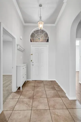 a view of a hallway with closet and chandelier