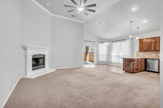a view of an empty room with a fireplace and a window