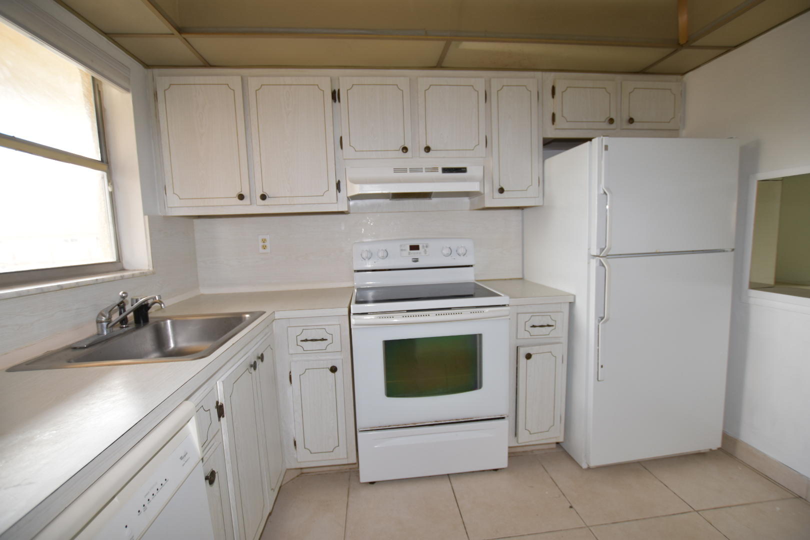 2780 North Pine Island Road, Unit 312 Sunrise, FL 33322 - Photo 2 of 30 a kitchen with white cabinets and white appliances