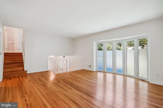 a view of a livingroom with wooden floor and stairs