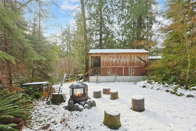 a view of a small house with a small yard and sitting area