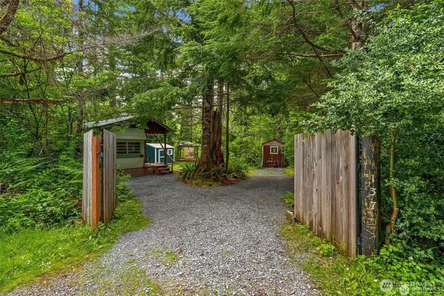 a view of a entrance gate with wooden fence and trees