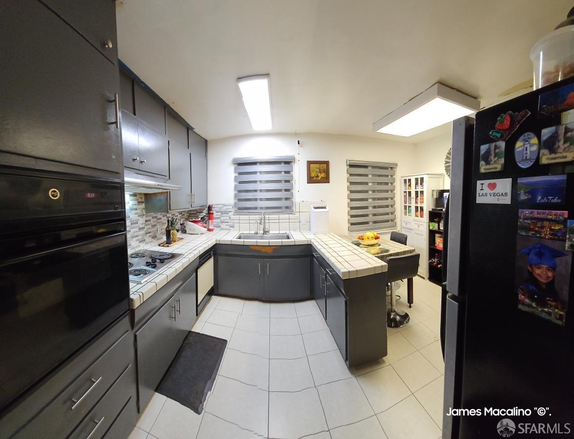 183 Mariposa Avenue Daly City, CA 94015 - Photo 22 of 27 a kitchen with a sink cabinets and stainless steel appliances