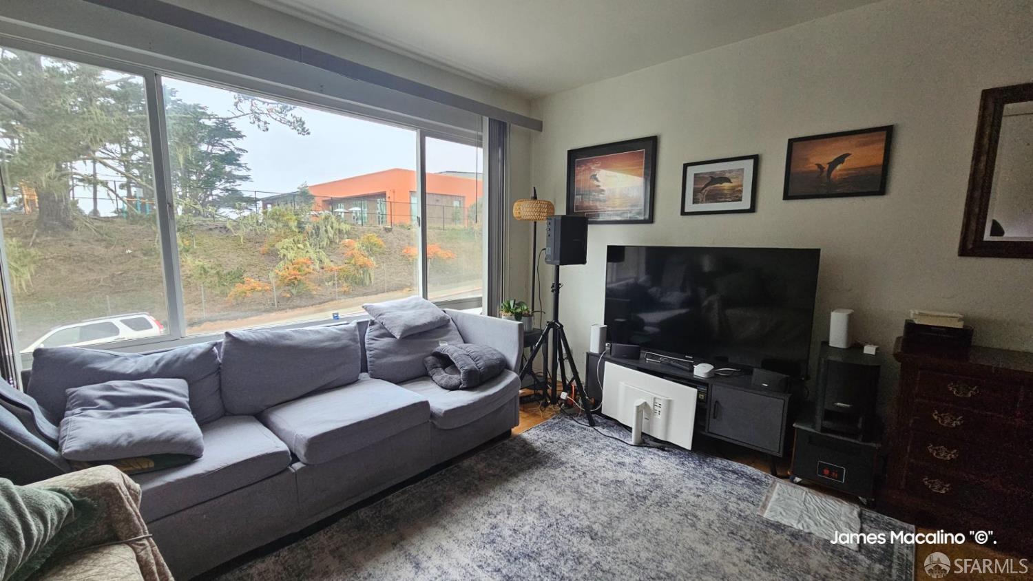 183 Mariposa Avenue Daly City, CA 94015 - Photo 23 of 27 a living room with furniture a flat screen tv and a floor to ceiling window