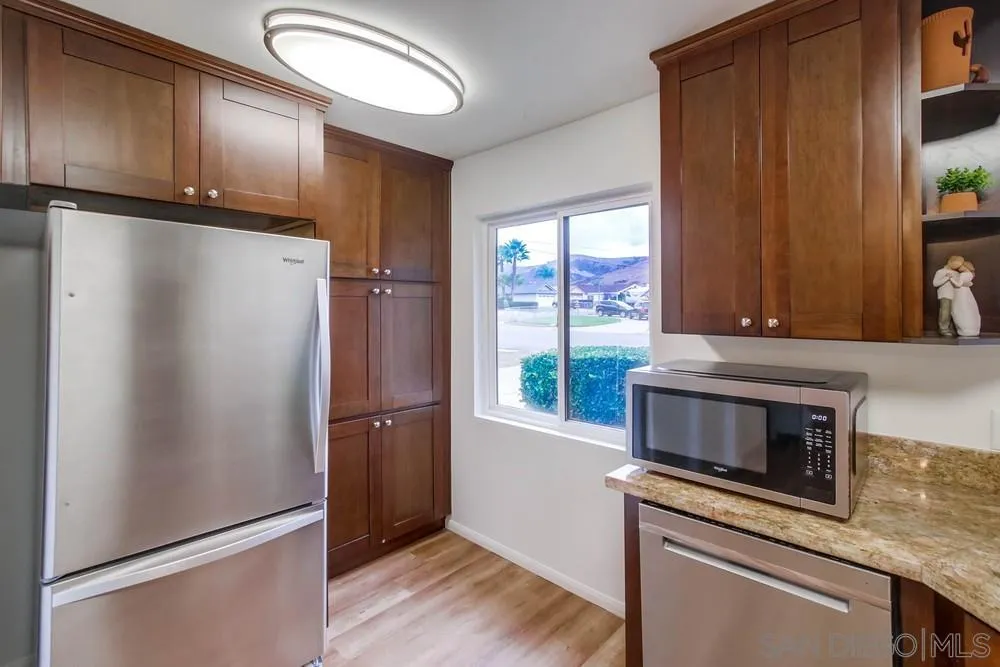 14574 Kennebunk Street Poway, CA 92064 - Photo 11 of 30 a kitchen with granite countertop a refrigerator and a stove top oven