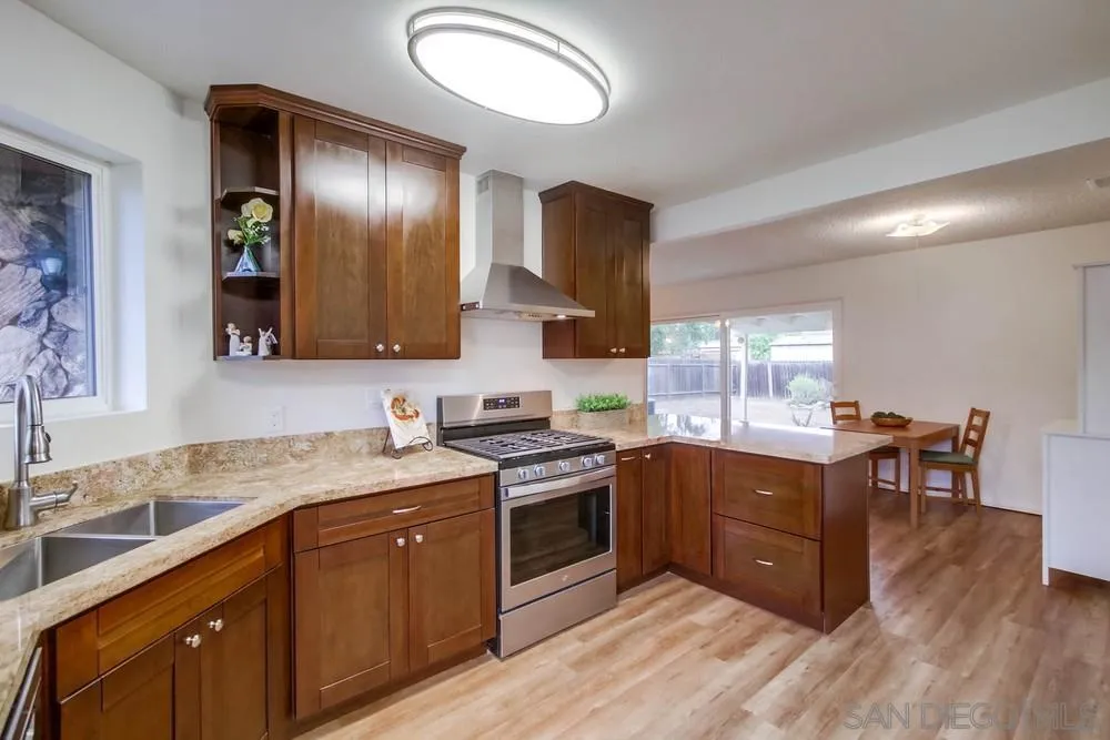 14574 Kennebunk Street Poway, CA 92064 - Photo 12 of 30 a kitchen with stainless steel appliances granite countertop a sink and stove top oven