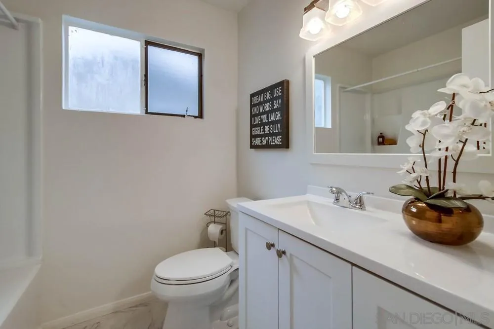 14574 Kennebunk Street Poway, CA 92064 - Photo 17 of 30 a bathroom with a toilet sink and mirror