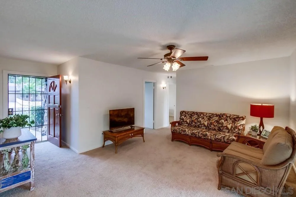 14574 Kennebunk Street Poway, CA 92064 - Photo 4 of 30 a living room with furniture a chandelier and a flat screen tv