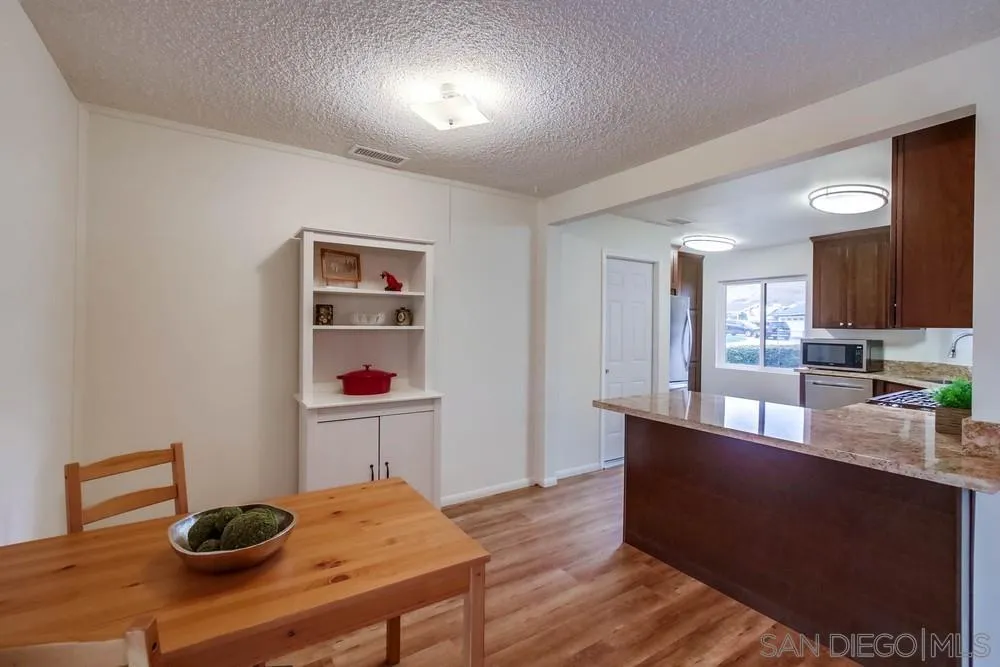 14574 Kennebunk Street Poway, CA 92064 - Photo 7 of 30 a kitchen with granite countertop cabinets a sink and wooden floor
