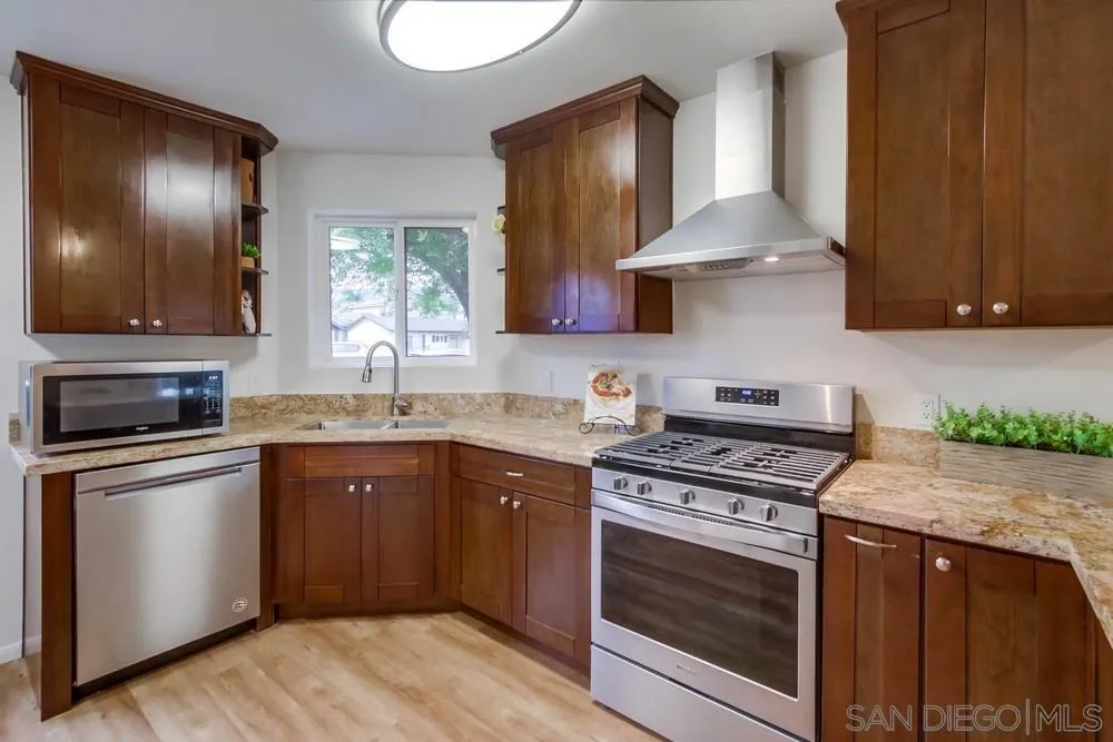 14574 Kennebunk Street Poway, CA 92064 - Photo 10 of 30 a kitchen with stainless steel appliances granite countertop a stove a sink and a microwave