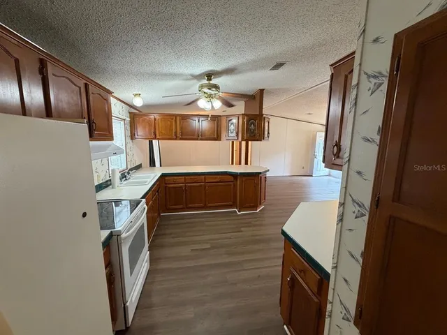 a view of kitchen with sink and refrigerator