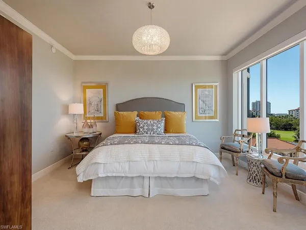 a bedroom with a bed and a large window