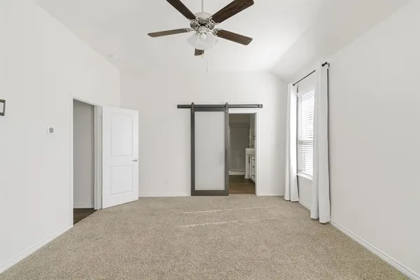 a view of an empty room with a ceiling fan