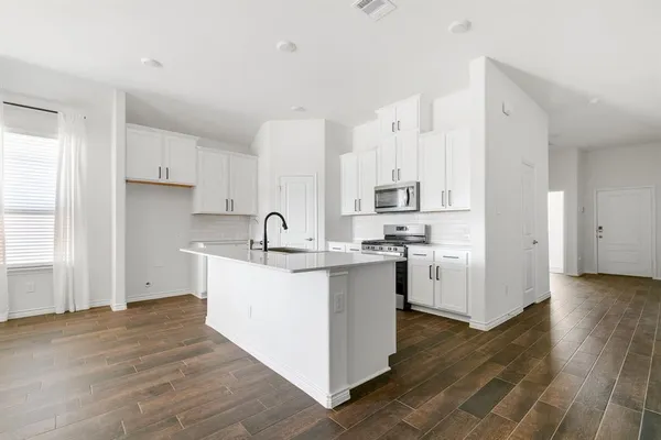 a kitchen with stainless steel appliances sink a stove and cabinets