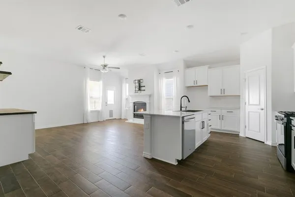 a large white kitchen with cabinets and wooden floor